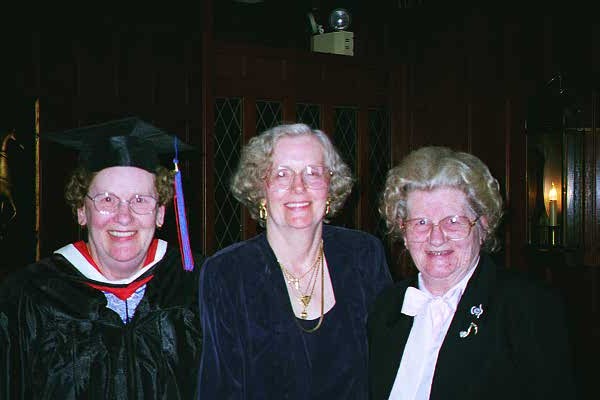 Photograph of Billie Lambert wearing a black graduation gown, with Lucy Barrasso and Alice Walmsley to her right.